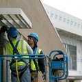 Randy Kaapuni, left, and Jose Zapata, both with Arkansas Glass & Mirror, install sun shades Friday o...