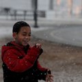Isaiah Perez, 7, makes a snowball Friday at Murphy Park in Springdale. Isaiah and his stepfather wer...