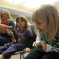 Snake enthusiast Lily Ginn, 4, right, observes the tail of a speckled kingsnake held by Rachel Diers...