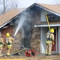 Springdale firefighters hose down the roof of a house at 1305 Daline St. in Springdale Wednesday, Ja...