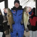 Andy Benson shows a smallmouth bass, left, and largemouth bass from the tournament’s winning catch. ...