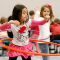 Myra Bui, left, 6, and Kadence Janney, 7, both of Rogers, hula-hoop inside the gymnasium Wednesday a...