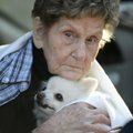 Charleta Logston comforts her dog “Tuffy” while keeping warm Thursday inside a vehicle as firefighte...