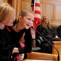 Judge Cristi Beaumont lifts daughter Megan Snively, 7, to the podium Thursday in front of the audien...