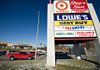 Cars pass a sign for a Target store outside a shopping mall in Peoria, Ill., this week. Target plans to promote its groceries and home products in an advertising campaign this year. 
