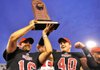 Arkansas State quarterback Ryan Aplin (left) hoists the Sun Belt Conference championship trophy with teammate Nathan Herrold on Dec 1. Aplin has remained one of the few constants on the team amid ASU’s coaching carousel. 