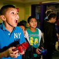 Salvador Aguilar, 10, left, of Avoca and Cesar Nava, 8, of Rogers play a video game Friday at the Bo...