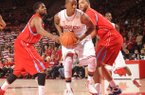 NWA Media/ANDY SHUPE -- Arkansas sophomore guard BJ Young, center, drives through the lane as Delaware State sophomore forward Tyshawn Bell, right, and junior forward Casey Walker, left, defend Saturday, Jan. 5, 2013, during the first half of play in Bud Walton Arena in Fayetteville.