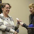 Kristi Mitchell, left, of Bentonville receives an inspirational poem Saturday from Mary White Schnei...