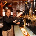 Maureen Robertson, a 10-year employee at Hog Haus, fills one of the restaurant and brewery’s growler...