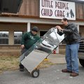 Jacob House, left, and Jared Laughlin, both of Fayetteville, move furniture into the new location of...