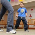 Luis Cruz, 7, watches Taylor Mills, Zumba instructor and children’s services assistant, while dancin...