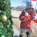 Kate Pendergraft, 17 months, runs around the Christmas tree Sunday at Frisco Station Park in downtow...
