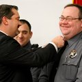 Benton County Sheriff Kelley Cradduck, left, pins new bars onto the collar of Patrol Lt. Randy Allsu...