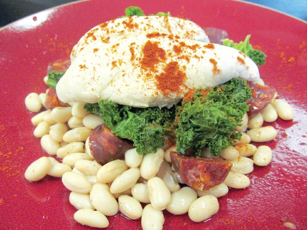 tender-poached-chicken-perched-atop-crisp-curly-kale-over-cannellini-beans-flavored-with-chorizo-sausage-bites-and-finished-with-smoked-sweet-paprika-combines-several-of-the-food-trends-expected-to-be-hot-in-2013