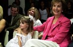FILE - In this Friday, May 19, 2006, file photo, Patsy Sutton, right, wife of then-Oklahoma State men's basketball coach Eddie Sutton, smiles as she sits with granddaughter Hallie Sutton, left, as she listens to her husband give his resignation speech during a news conference in Stillwater, Okla. Patsy Sutton, 74, died Tuesday, Jan. 8, 2013, at a Tulsa, Okla., hospital, officials at Ninde Brookside Chapel say. (AP Photo/File)