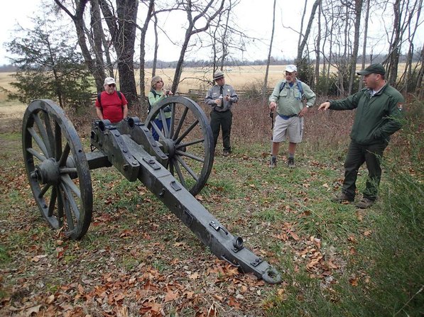 Hikers look over the chassis of a Civil War cannon replica.