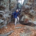 Bob Ross and Mary Chodrick hike along rock formations.