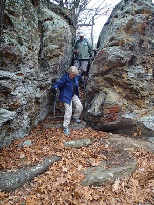 Bob Ross and Mary Chodrick hike along rock formations.