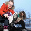 Amanda Mandras, right, sits next to her daughter, Tegan Mandras, 13, as they lace up their ice skate...