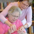 June Meunier of Fayetteville, right, a volunteer instructor, reaches Wednesday to help Nola Magee of...