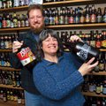 Duncan and Sharon McKinnon stand in front of their bottle collection Tuesday at their West Fork home...