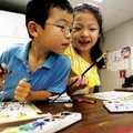 Torrie Pianalto, left, and Sophia Flores, both of Springdale, share a paint palette at the Arts Cent...