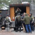 The Benton County Sheriff’s Office SWAT team gears up to work a standoff Thursday on Hickory Lane in...