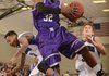 Fayetteville’s Manuale Watkins, center, grabs a rebound over Rogers’ Xavier Smith, right, and Jake Killingsworth during Friday’s game at King Arena in Rogers. 