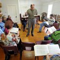 Syd Caldwell of Lowell leads the Sacred Harp Singers as they practice Sunday afternoon during their ...