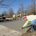Brandon Williams with Fayetteville’s Transportation Division, uses a trowel Thursday to smooth newly...
