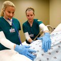 Shelly Lee, left, of Fayetteville and Jessica Abramson of Springdale check Friday on a pregnant dumm...