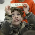 Gabriel Creasey, 9, checks out the $1 bill he received Friday while attending a program on saving mo...