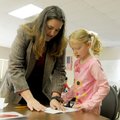 Kate Coleman, astronomy professor at NorthWest Arkansas Community College, helps Kira Baucom, 6, fol...