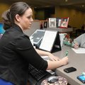 Katesha Schemerhorn, left, student records specialist, writes down information for Corinne Lawyer Th...