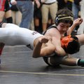 Aaron Grigsby, top, of Bentonville High School locks his arm around the neck of David Zamora of Roge...