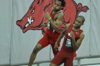 NWA Media/MICHAEL WOODS --01/25/2013-- Arkansas runner Akheem Gauntlett (front) and Nebraska runner Dexter McKenzie round the last turn in the men's 200m run during Friday night's action in the Razorback Invitational at the Randal Tyson Track Center in Fayetteville.