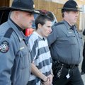 Zachary Holly, center, is escorted to a Benton County Sheriff’s Office patrol car Nov. 28 after an b...