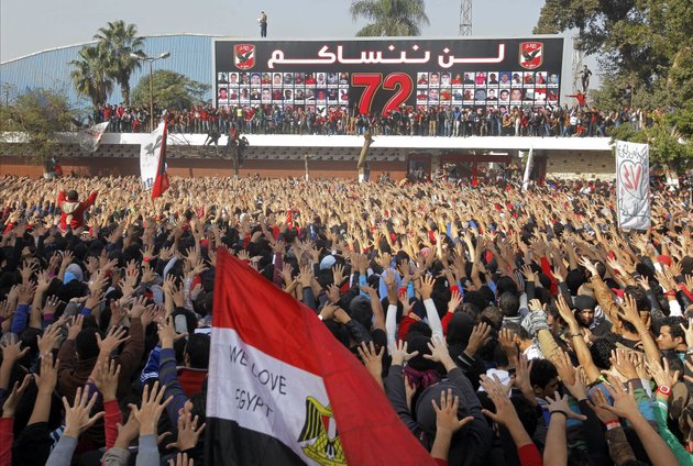 egyptian-soccer-fans-of-al-ahly-club-celebrate-a-court-verdict-that-returned-21-death-penalties-in-last-years-soccer-violence-inside-the-club-premises-in-cairo-egypt-saturday-jan-26-2013-egyptian-security-officials-say-military-to-deploy-in-port-said-after-at-least-8-people-died-in-the-mediterranean-city-of-port-said-after-a-judge-sentenced-21-people-to-death-in-connection-to-one-of-the-worlds-deadliest-incidents-of-soccer-violence-arabic-reads-we-will-never-forget-you