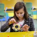 Chloe Sandoval, 9, from Fayetteville shakes the excess glitter off of her paper snowflake Saturday a...