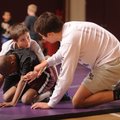 Coach Austin Riddle, right, helps instruct 9-year-old wrestlers Sam Lannutti, top, and Josh Cartwrig...