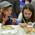 Aubrey Holloway, left, 8, and Megan Treacy, 8, both from Rogers, talk as they eat pancakes and read ...