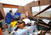 Volunteers, neighbors and emergency personnel work Tuesday, Jan. 29, 2013, to recover personal items from Orvetta Cox's home on Hummingbird Road in Fayetteville after the house was damaged by storms.