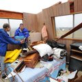 Volunteers, neighbors and emergency personnel work Tuesday, Jan. 29, 2013, to recover personal items...