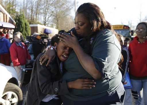 a-woman-comforts-a-child-after-after-a-shooting-at-an-price-middle-school-in-atlanta-thursday-jan-31-2013-a-14-year-old-boy-was-wounded-outside-the-school-thursday-afternoon-and-a-fellow-student-was-in-custody-as-a-suspect-authorities-said-no-other-students-were-hurt