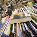 Jayden Swartz, 10, a third-grader, flips through a book Wednesday while looking for three books to c...