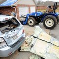 Kody Krummel operates a tractor as crews clean up damage at a duplex next to an orthodontist office ...