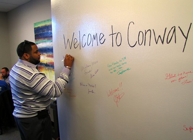 korry-garrett-signs-a-wall-at-the-announcement-thursday-jan-31-2013-that-internet-marketing-and-technology-firm-inuvo-is-moving-to-conway