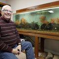 Denny Rogers sits in his favorite personal space, one of the aquarium rooms he has set up at his hom...