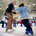 Kayla Church, 14, left, of Cave Springs helps Anna Main, 5, of Siloam Springs across the ice Saturda...